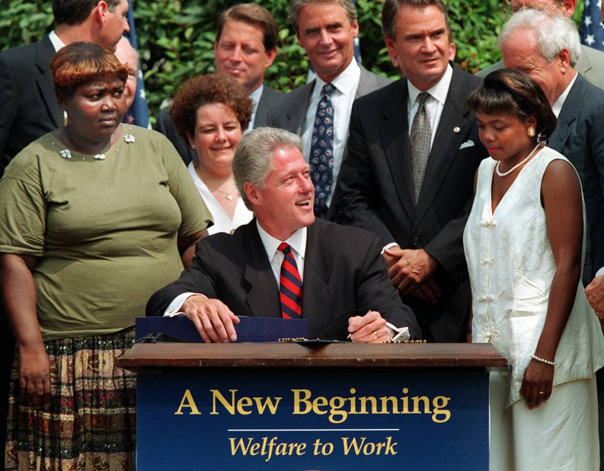 הנשיא ביל קלינטון חותם על חוק הרווחה החדש. צילום: סוכנת AP.