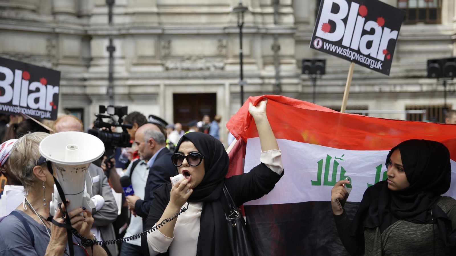 הפגנה של אזרחים בריטים ממוצא עיראקי מחוץ לאולם בוא הוצג הדוח צילום: סוכנות AP.