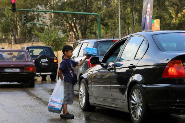 עלי חמאדה, שנמלט עם משפחתו מחלב, מוכר ממחטות נייר לנהגים בבירות.  צילום: סוכנות AP.