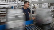 עובד במפעל שתייה. צילום: יונתן סינדל / פלאש 90.