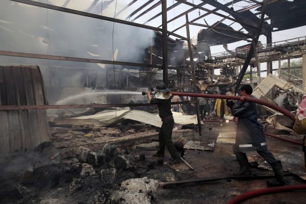 כבאים מנסים לכבות שריפה במפעל מזון בצנעא,תימן, שהופצץ ע"י סעודיה, 9 באוגוסט 2016 (צילום: AP).