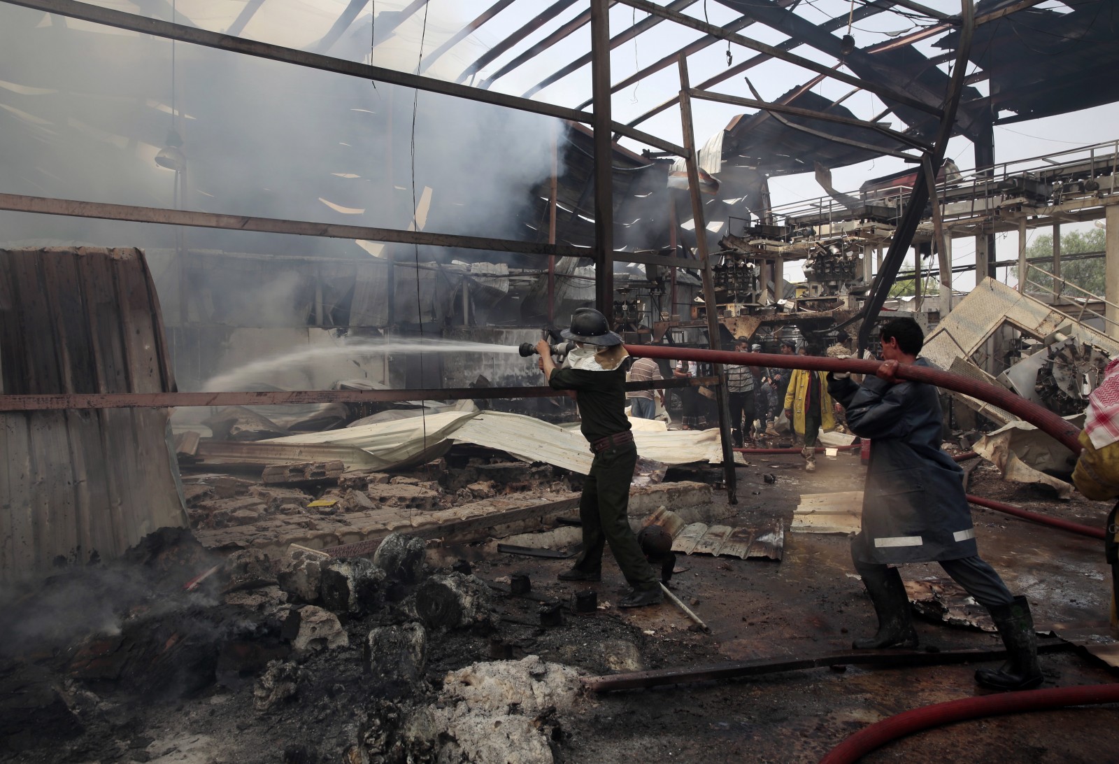 כבאים מנסים לכבות שריפה במפעל מזון בצנעא,תימן, שהופצץ ע&quot;י סעודיה, 9 באוגוסט 2016 (צילום: AP).