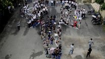 ילדי בית ספר בניו דלהי עומדים על קו מתאר של ראש של פיל ביום הפיל הבינלאומי. (AP Photo/Altaf Qadri).