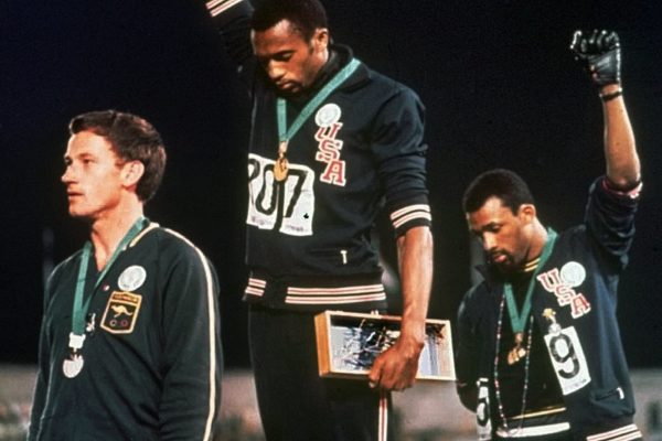 הצדעת הכוח השחור באולימפיאדת מקסיקו 1968 - ג'ון קרלוס (מימין) טומי סמית'  ופיטר נורמן בטקס הענק המדליות בריצת 200 מטר (צילום: AP)