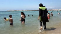אשה לבושה בבורקיני – בגד ים המיועד לנשים מוסלמיות מסורתיות, בחוף הים בדרום צרפת. אוגוסט 2016. (צילום: סוכנות AP).