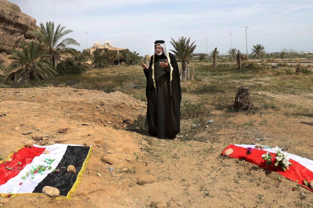 אדם מתאבל על קבר אחים בו קבורים כנראה אזרחים שהיו בעבר חיילים בצבא עיראק ונטבחו ע"י דאעש. יוני 2015(צילום:סוכנות AP).