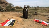 אדם מתאבל על קבר אחים בו קבורים כנראה אזרחים שהיו בעבר חיילים בצבא עיראק ונטבחו ע"י דאעש. יוני 2015(צילום:סוכנות AP).