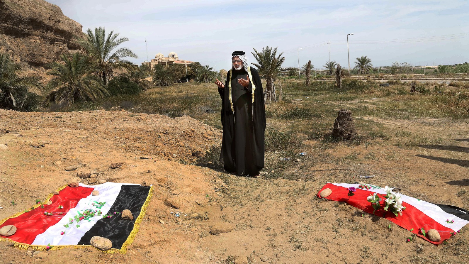 אדם מתאבל על קבר אחים בו קבורים כנראה אזרחים שהיו בעבר חיילים בצבא עיראק ונטבחו ע&quot;י דאעש. יוני 2015(צילום:סוכנות AP).