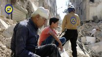 תושבים יושבים בהריסות ביתם בעיר חלב, סוריה (צילום: ארגון ׳הקסדות הלבנות׳ / סוכנות AP).