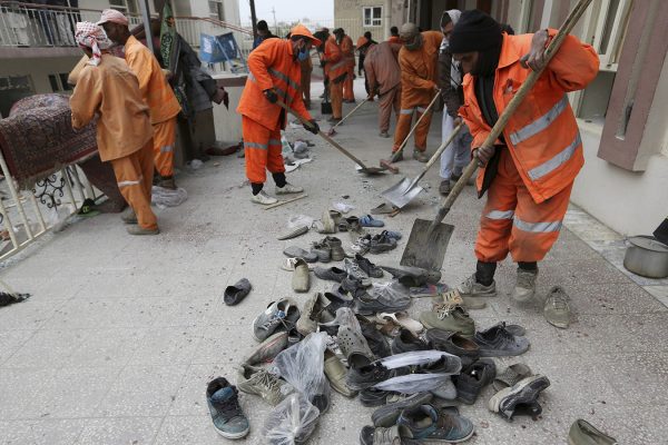 עובדי עיריה מפנים נעלי קורבנות מפיגוע ההתאבדות במסגד בקאבול, אפגניסטן (צילום: סוכנות AP).
