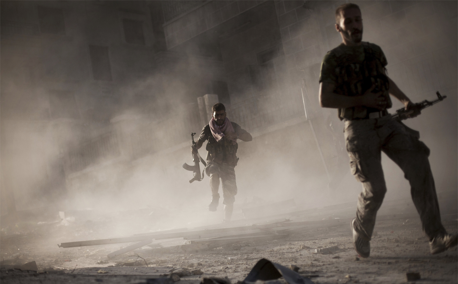 חיילים בצבא סוריה החופשית נמלטים לאחר תקיפת טנק של משטר אסד בחלב (צילום AP).