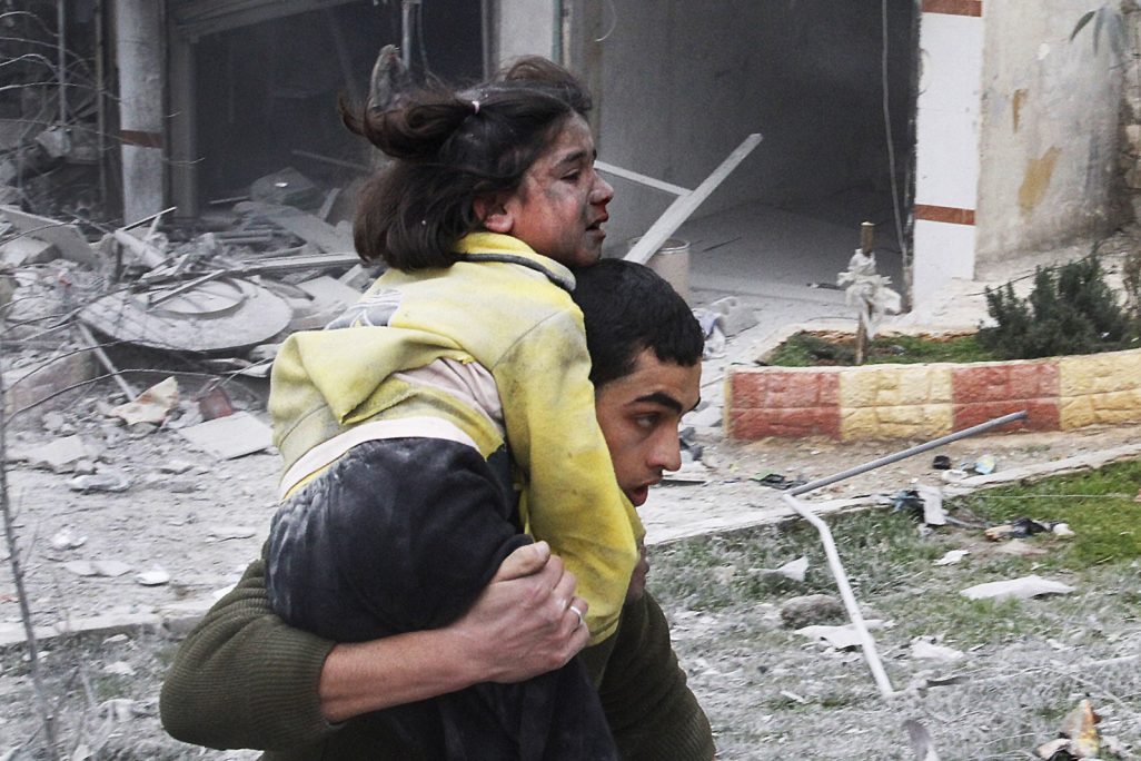 אח נושא את אחותו הפצועה לאחר הפצצה אווירית בשכונה בחלב (צילום AP).