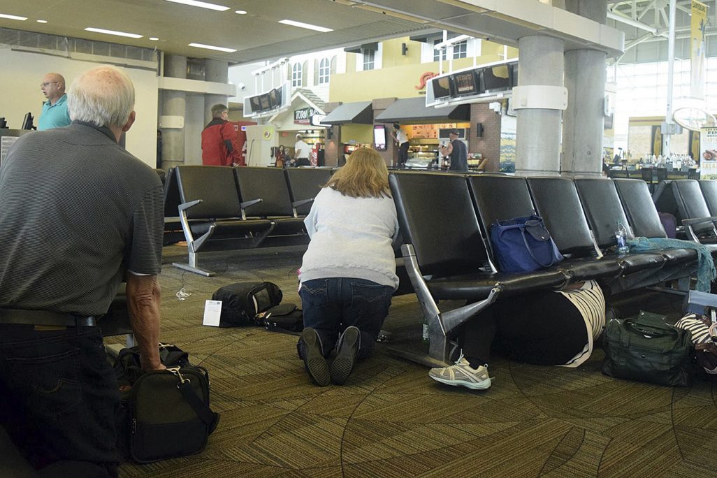 נוסעים תופסים מחסה בשדה התעופה בפלורידה בעקבות הירי (צילום: סוכנות AP).