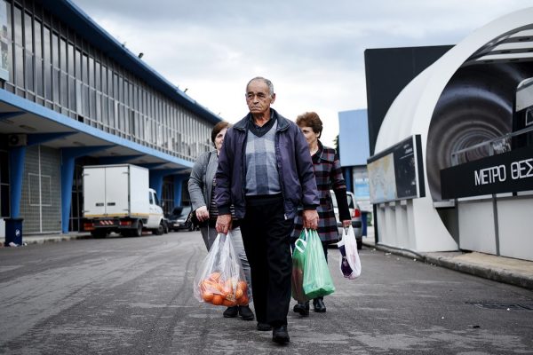 אזרחים בדרכם הביתה לאחר שקיבלו מזון בנקודת חלוקה ממשלתית (צילום: Giannis Papanikos / Shutterstock, Inc)