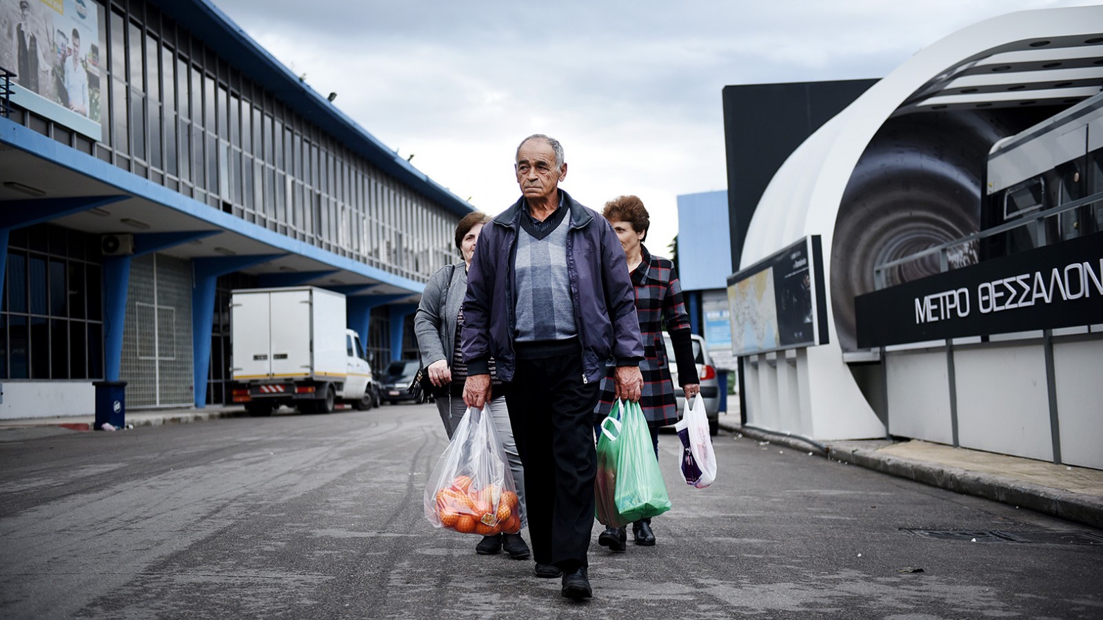 יוונים עניים בדרכם הביתה לאחר שקיבלו מזון בנקודת חלוקה ממשלתית (צילום: Giannis Papanikos / Shutterstock, Inc)