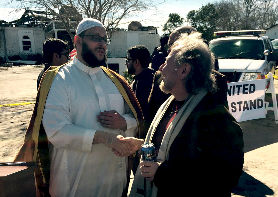 דר' רוברט לאוב, ועמיתו דר' שהיד חאסימי, מנהיגי הקהילות היהודית והמוסלמית בויקטוריה, על רקע המסגד השרוף (באדיבות אלה טרייסי אוליבר).