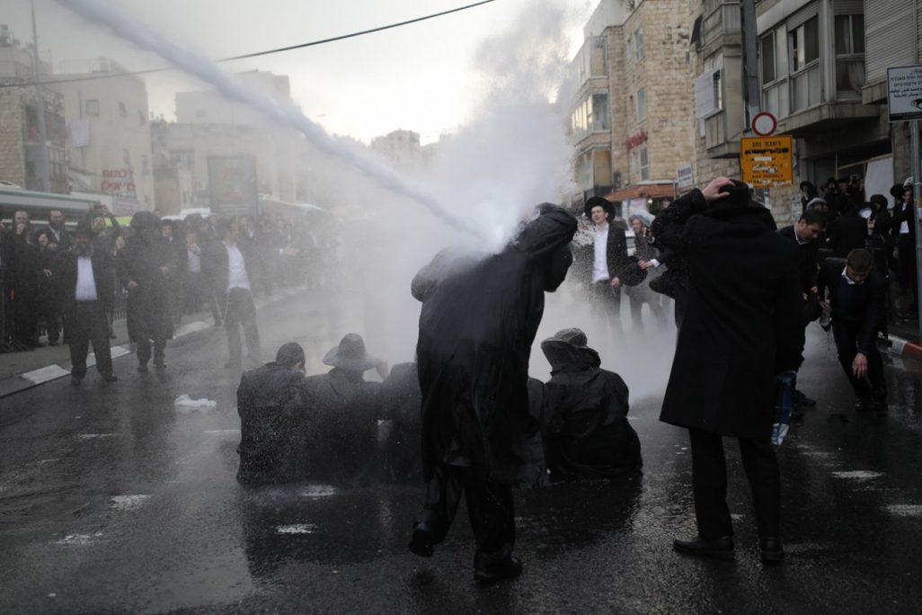 מפגינים חרדים מופגזים בזרנוקי מים בהפגנה במאה שערים בירושלים (צילום: יונתן זינדל/ פלאש 90).