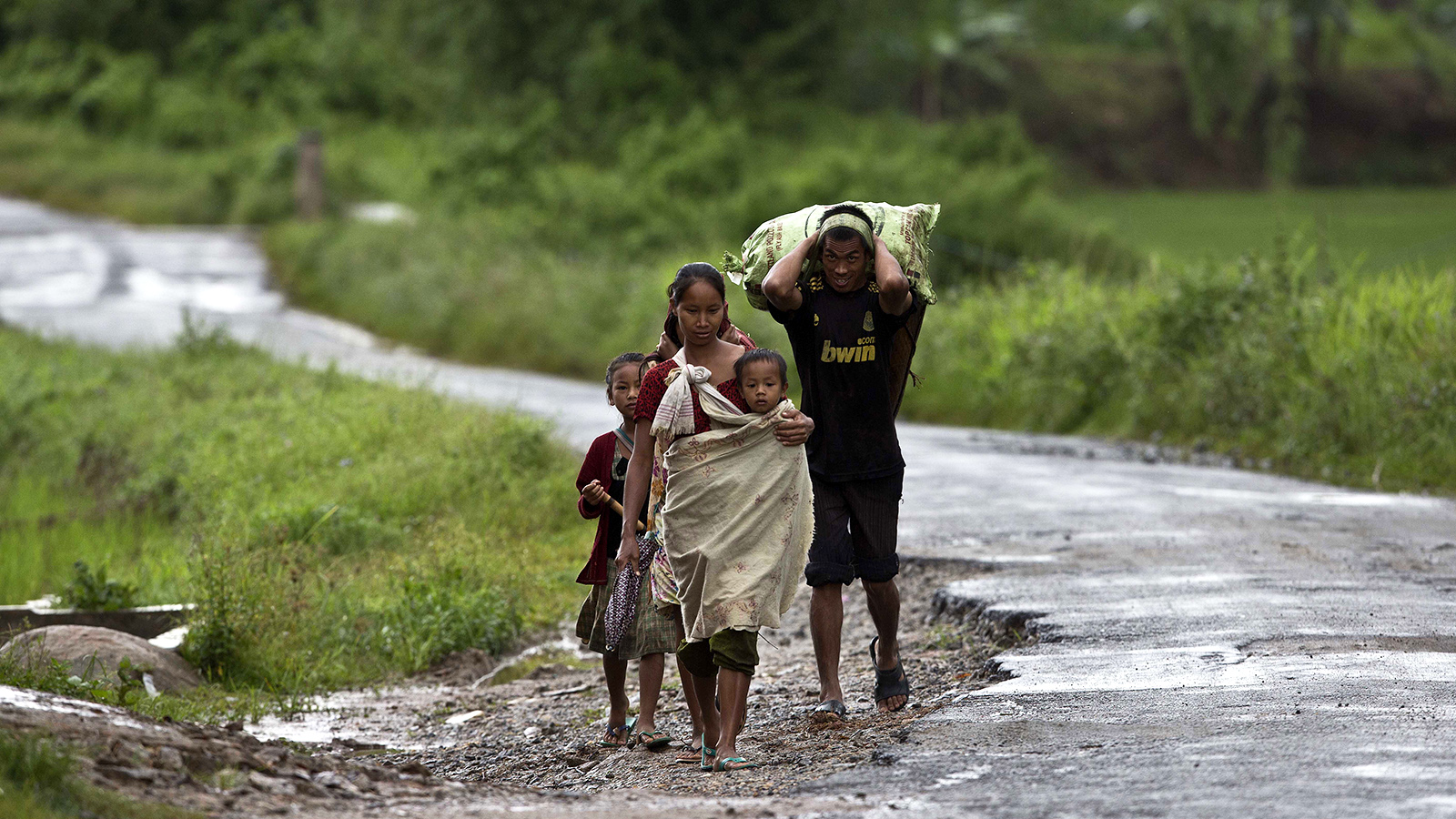 משפחה חוזרת לביתה אחרי יום עבודה בשדה בהודו (צילום: AP Photo/Anupam Nath).