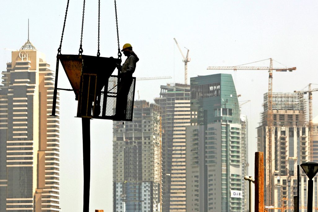 עובד בניין על מנוף בדובאי (צילום: AP Photo/Kamran Jebreili).