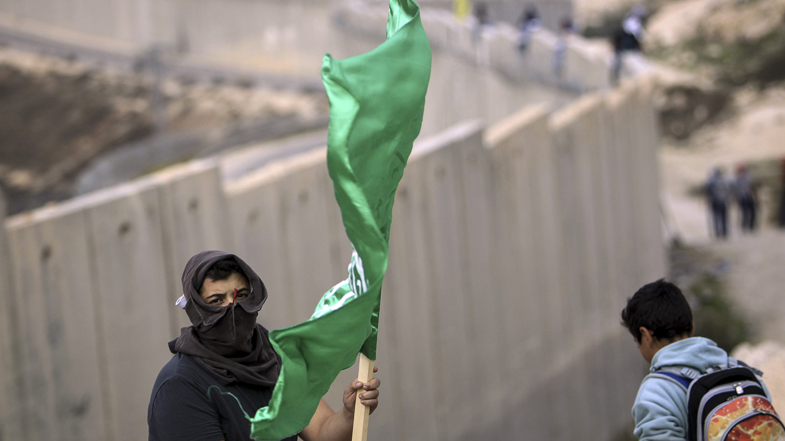 צעיר פלסטיני מניף דגל חמאס (צילום: Muammar Awad / פלאש 90).