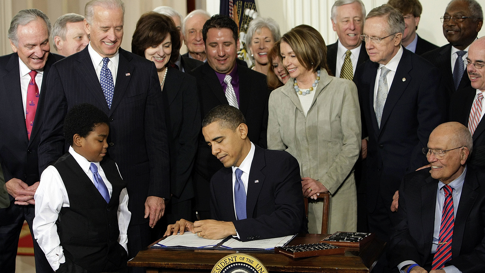 אובמה חותם על חוק הבריאות המכונה 'אובמה-קר' במרץ 2010. (צילום: AP Photo/J. Scott Applewhit).