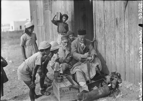 סנדלר תימני וסביבו ילדים, כפר אלישיב, 1939. אוסף הצילומים הייחודי של זולטן קלוגר (אתר ארכיון המדינה).