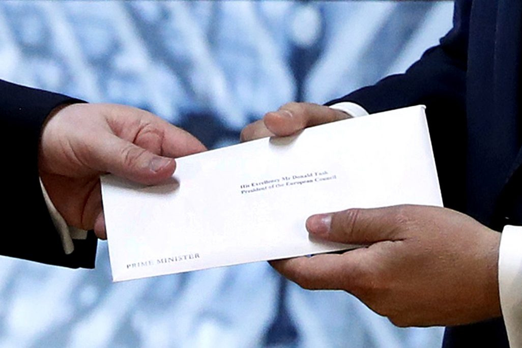 הנציג הקבוע של בריטניה בבירת האיחוד האירופי בריסל, סר טים בארו (משמאל) מגיש את מכתב הפרישה של בריטניה מהאיחוד האירופי לנשיא המועצה האירופית, דונלד טוסק. (צילום: Yves Herman/Pool Photo via AP)