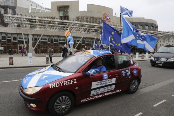 אזרחית תומכת בהיפרדות סקוטלנד מבריטניה חולפת על פני הפרלמנט הסקוטי ﻿﻿ (ארכיון)  (Andrew Milligan/PA via AP)