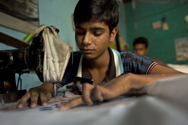 תופר בן 14 במתפרה בהודו (צילום ארכיון: AP Photo/Anupam Nath).