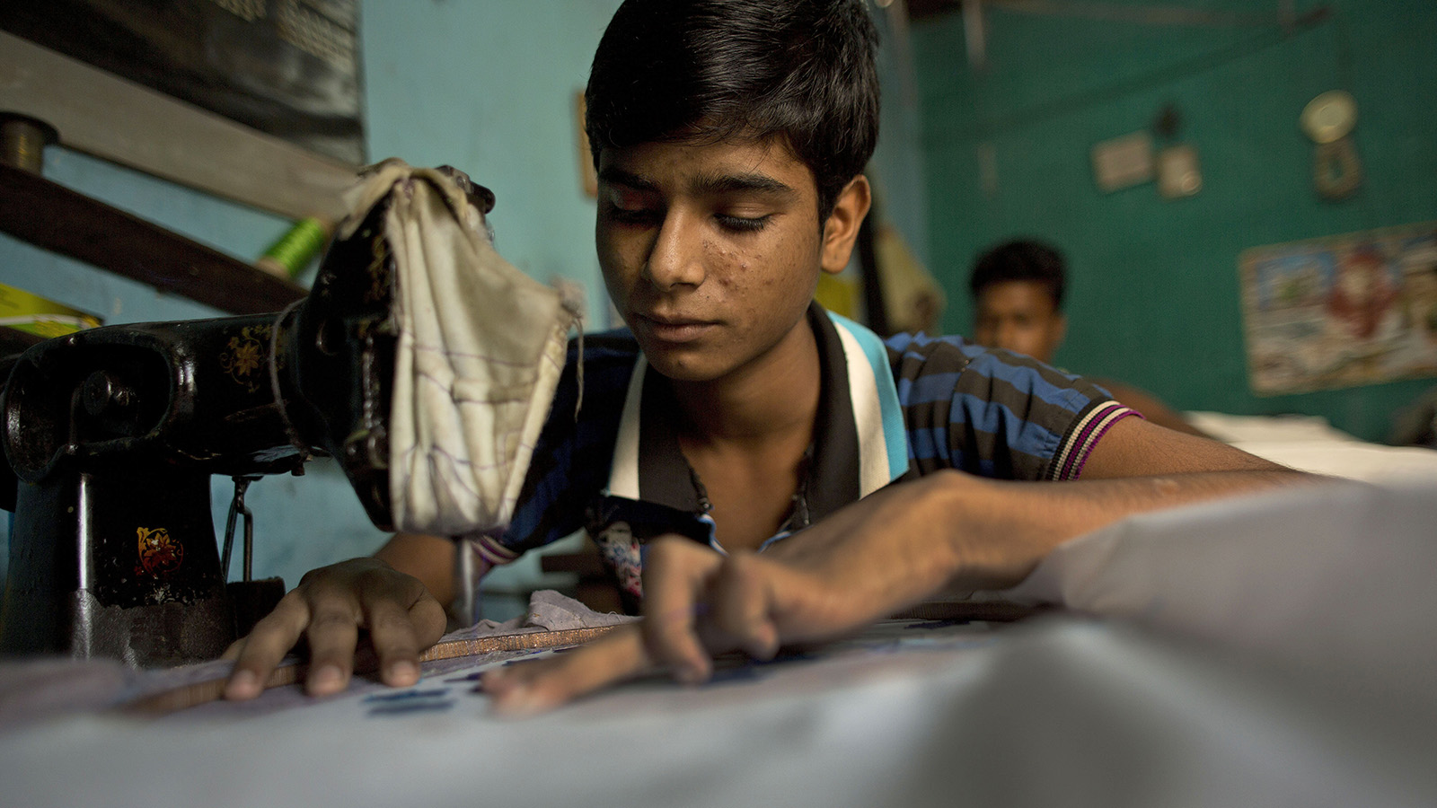 תופר בן 14 במתפרה בהודו (צילום ארכיון: AP Photo/Anupam Nath).