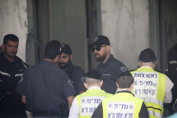 אנשי זק"א ומשטרה בזירה באתר הבניין בו נמצאה גופת האישה (צילום: פלאש 90).