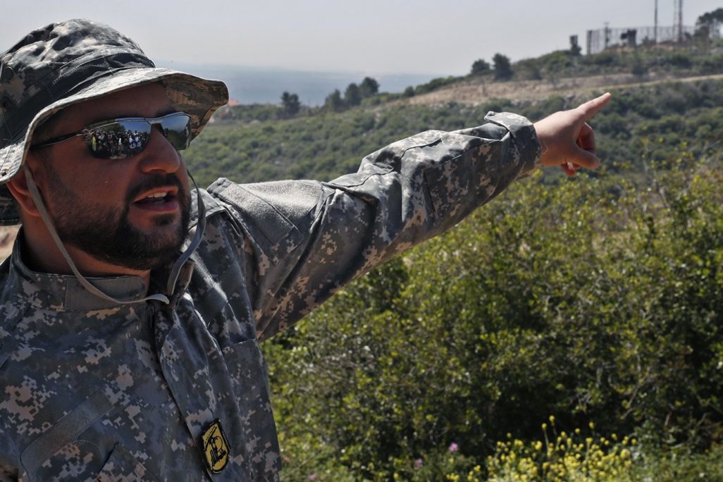 קצין חיזבאללה מצביעי על עמדת צה"ל בגבול לבנון בסיור שערך ארגון חיזבאללה לתקשורת (צילום: AP Photo/Hussein Malla).