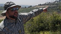 קצין חיזבאללה מצביעי על עמדת צה"ל בגבול לבנון בסיור שערך ארגון חיזבאללה לתקשורת (צילום: AP Photo/Hussein Malla).