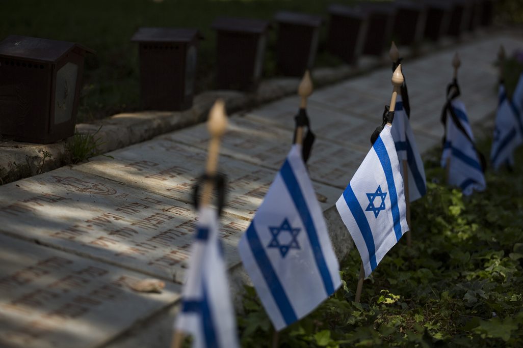 דגלים מונחים על קברים בחלקה הצבאית בהר הרצל (צילום: יונתן זינדל/ פלאש 90).