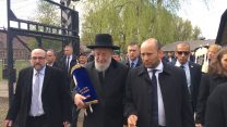 הרב ישראל מאיר לאו בכניסה למחנה אושוויץ (ללא קרדיט).