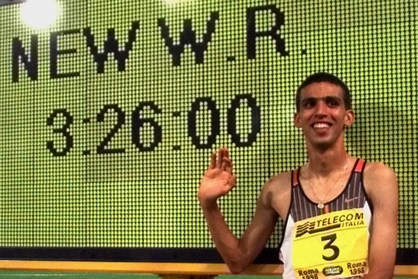 האצן המרוקאי הישאם אל גארוז' לצד שלט התוצאה של שיא העולם בריצת 1500 מטר אותו קבע ב1998(צילום: AP Photo/Andrew Medichini).