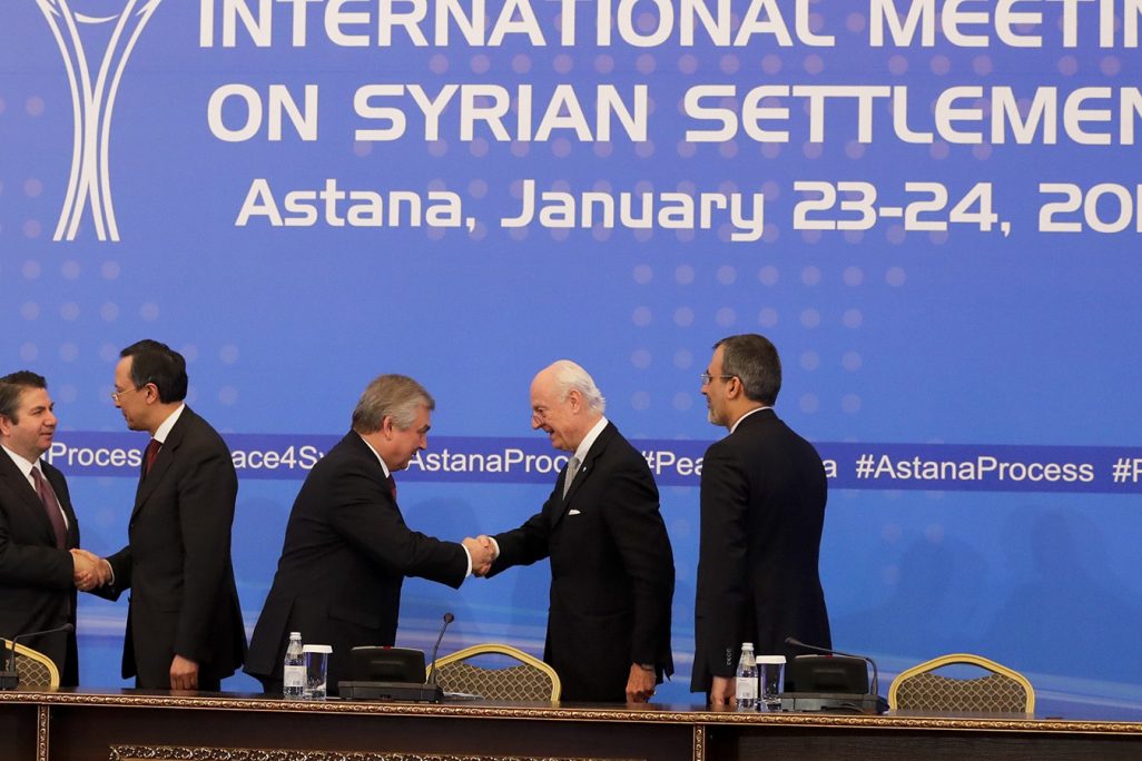 סגן שר החוץ הטורקי, סדאט אונל (משמאל), ושר החוץ הקזחי, קייראט עבדרחמנוב לוחצים ידיים בכינוס באסטנה, ינואר 2017. (צילום: AP Photo/Sergei Grits)