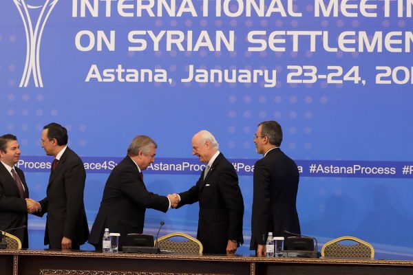 סגן שר החוץ הטורקי, סדאט אונל (משמאל), ושר החוץ הקזחי, קייראט עבדרחמנוב לוחצים ידיים בכינוס באסטנה, ינואר 2017. (צילום: AP Photo/Sergei Grits)