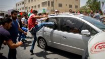 מפגינים פלסטינים מקיפים רכב של מתנחל שע"פ עדויות ירה במפגין ובעיתונאי (צילום: נאסר ישתעיא / פלאש 90).