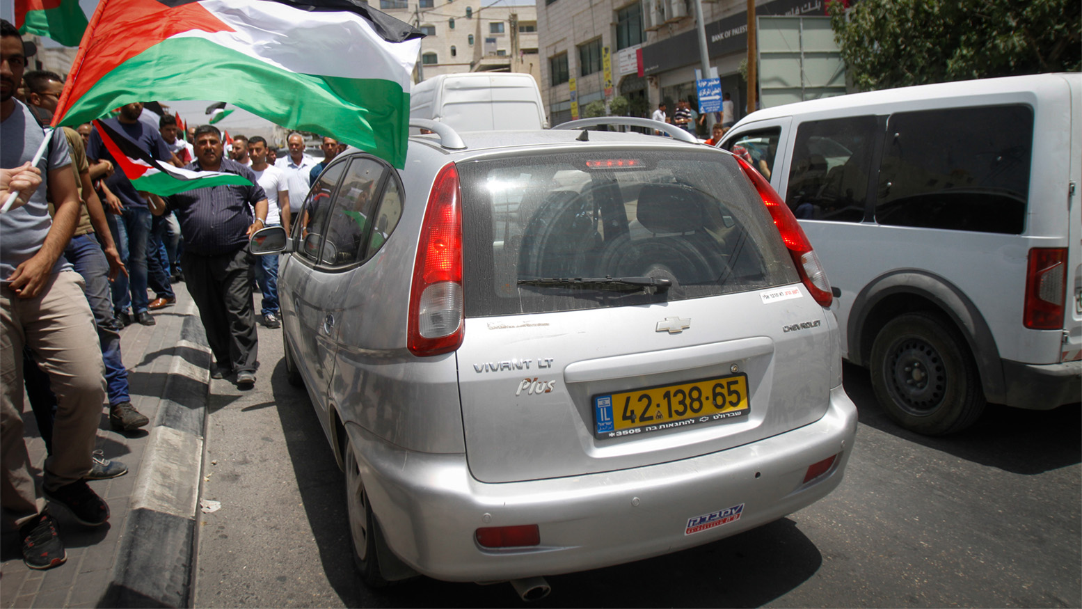 מפגינים פלסטינים מקיפים רכב של מתנחל שע&quot;פ עדויות ירה במפגין ובעיתונאי (צילום: נאסר ישתעיא / פלאש 90).