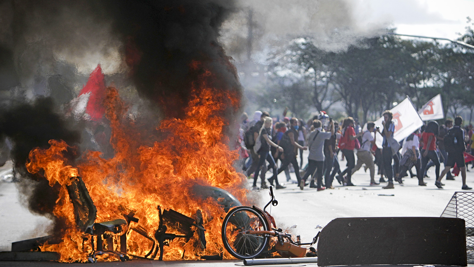 מפגינים צועדים בסמוך לבריקדות שהובערו לאות מחאה כנגד הממשלה (צילום: AP Photo/Eraldo Peres)