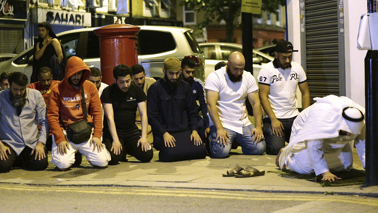 תושבים מתפללים ליד המסגד בו התרחש אירוע הדריסה בלונדון אמש (Yui Mok/PA via AP)