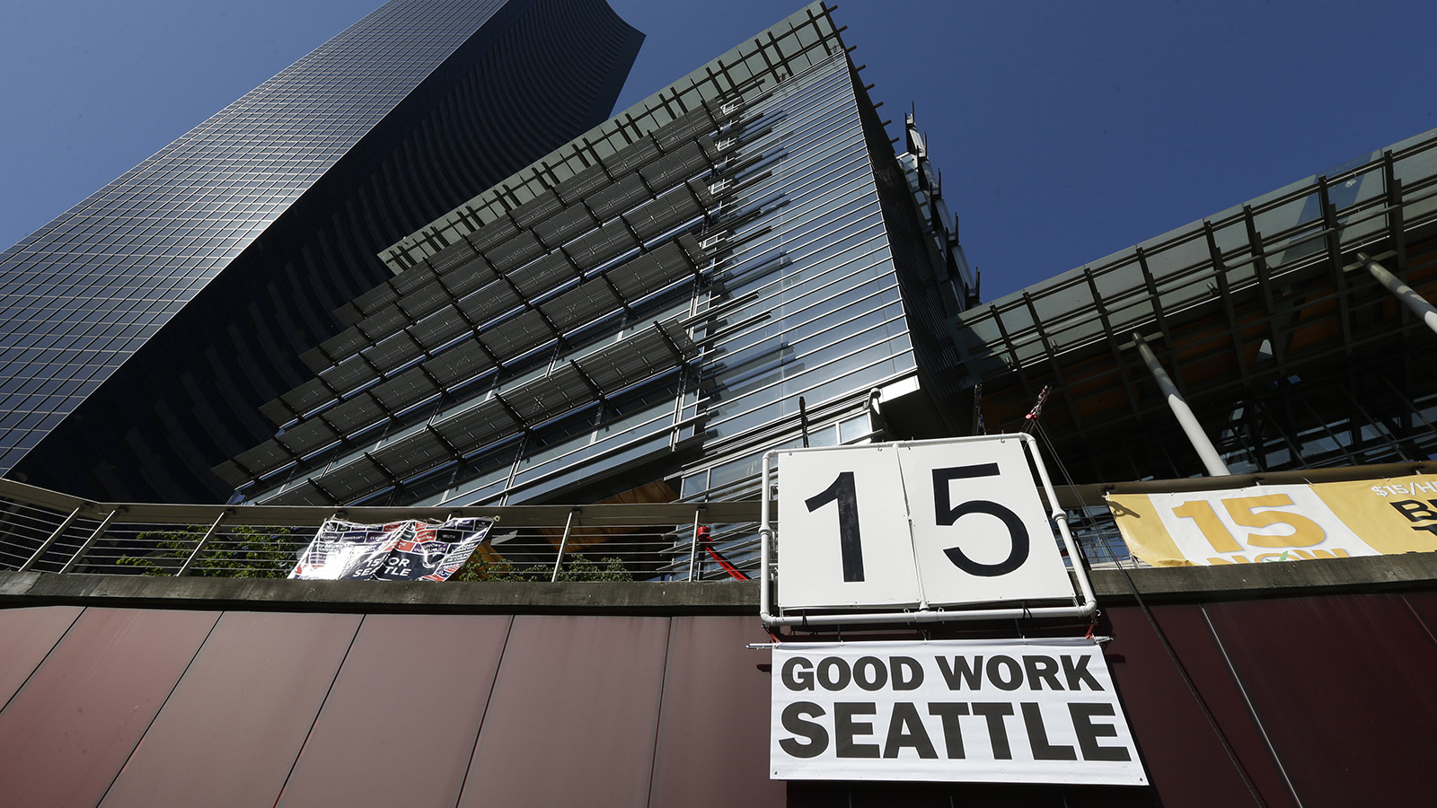 שלט מחאה להעלאת שכר המינימום ל-15 דולר בסיאטל (צילום ארכיון: AP Photo/Ted S. Warren, File).