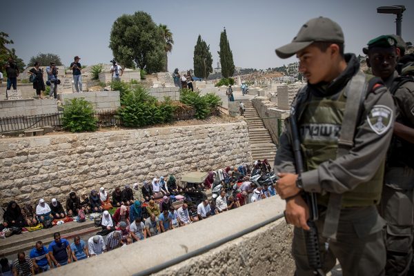 שוטרי מג"ב משיקפים על מתפללים מול שער האריות בעיר העתיקה בירושלים (צילום: מרים אלטשר/ פלאש 90).