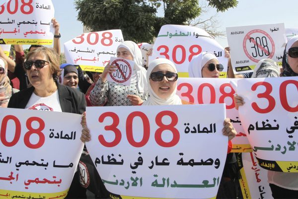 נשים ירדניות מפגינות מחוץ לפרלמט לקראת ההצבעה על סעיף 308 אתמול. על השלטים נכתב: "סעיף 308 הוא חרפתה של מערכת הצדק הירדנית" "סעיף 308 לא מגן על כבוד - הוא מגן על פושעים" (AP Photo/Reem Saad)