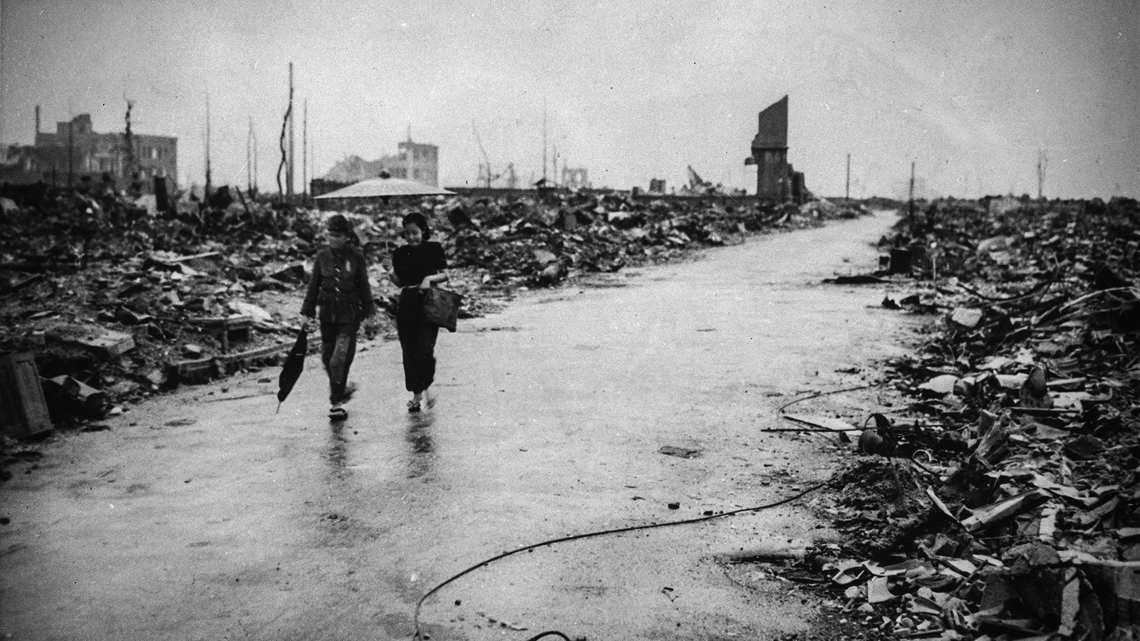 שני אנשים הולכים בדרך שפונתה מהריסות הירושימה לאחר הטלת פצצת האטום, 6.8.45 (צילום ארכיון: AP Photo/U.S. Air Force).