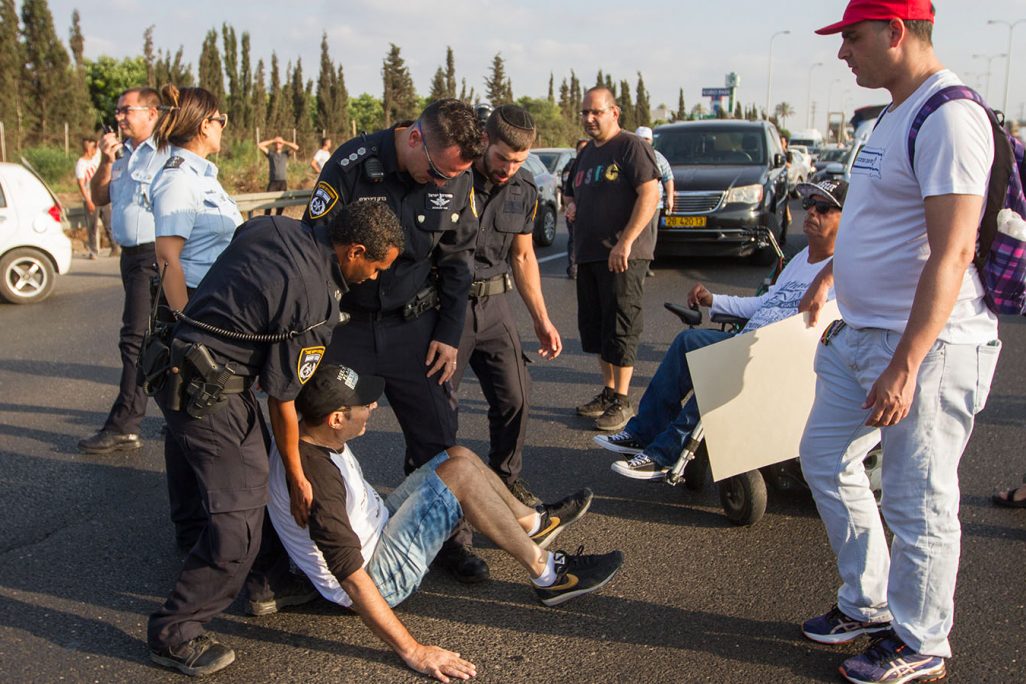שוטרים עוצרים נכים ופעילים במאבק להעלאת קצבאות הנכות לאחר  שחסמו את כביש 2. 14 באוגוסט (צילום: פלאש 90)