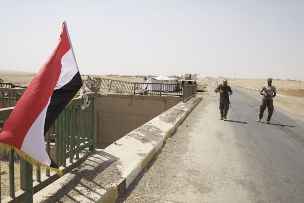 שני חיילים עיראקיים מאבטחים גשר על הדרך לתל-עפר, 14 באוגוסט 2017. הממשלה העיראקית החלה להציב כוחות מסביב לעיר כהכנה למתקפה על אחד המעוזים העירוניים האחרונים שבשליטת דאע"ש בצפון עיראק. (צילום: AP Photo/Balint Szlanko)