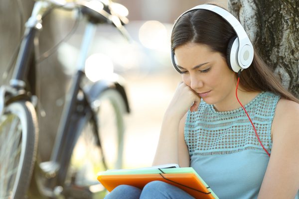 אישה מאזינה לספר דיגיטלי, אילוסטרציה (צילום: shutterstock).