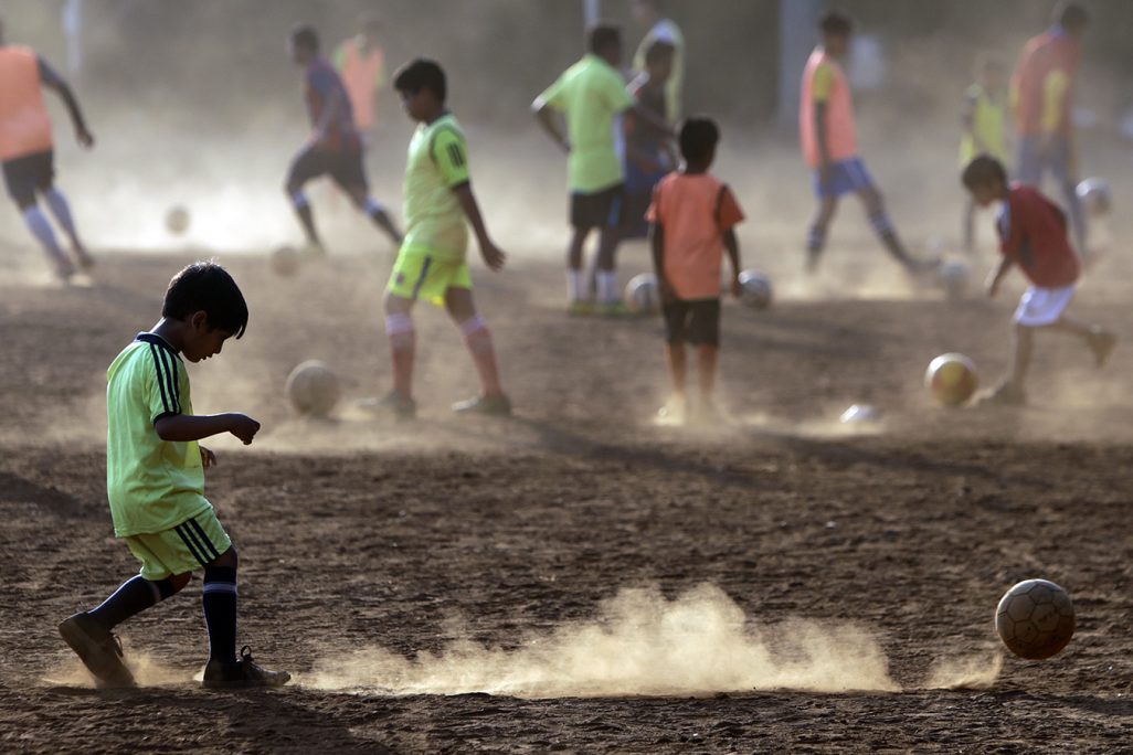 ילדים הודים משחקים כדורגל במומבאי (צילום: AP Photo/Rajanish Kakade).